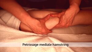 Petrissage of kneding op de mediale hamstring bij een wielrenner.